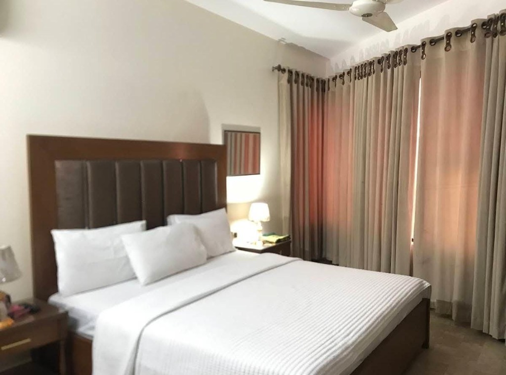Room with white bed and brown headboard