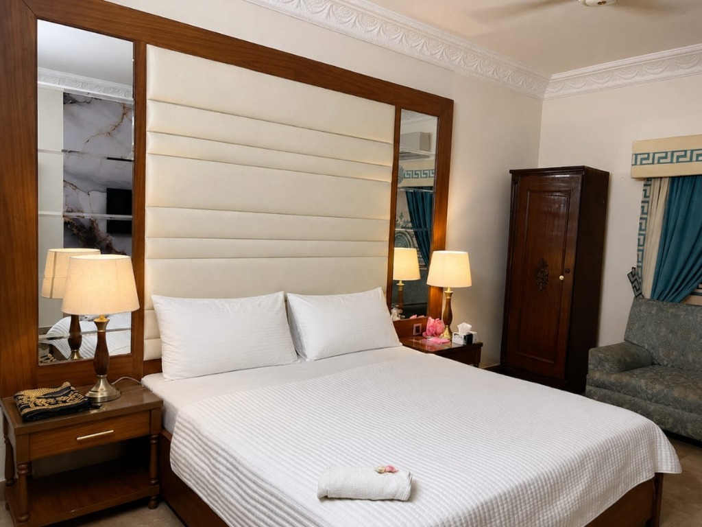 Standard Room with brown headboard and white bedding