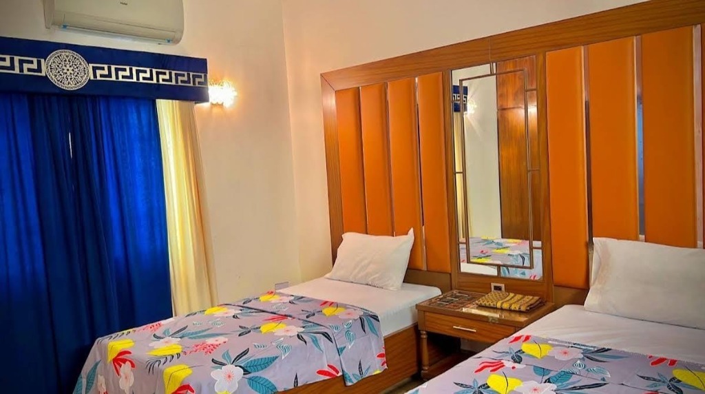 Twin Standard Room with two single beds and blue curtains